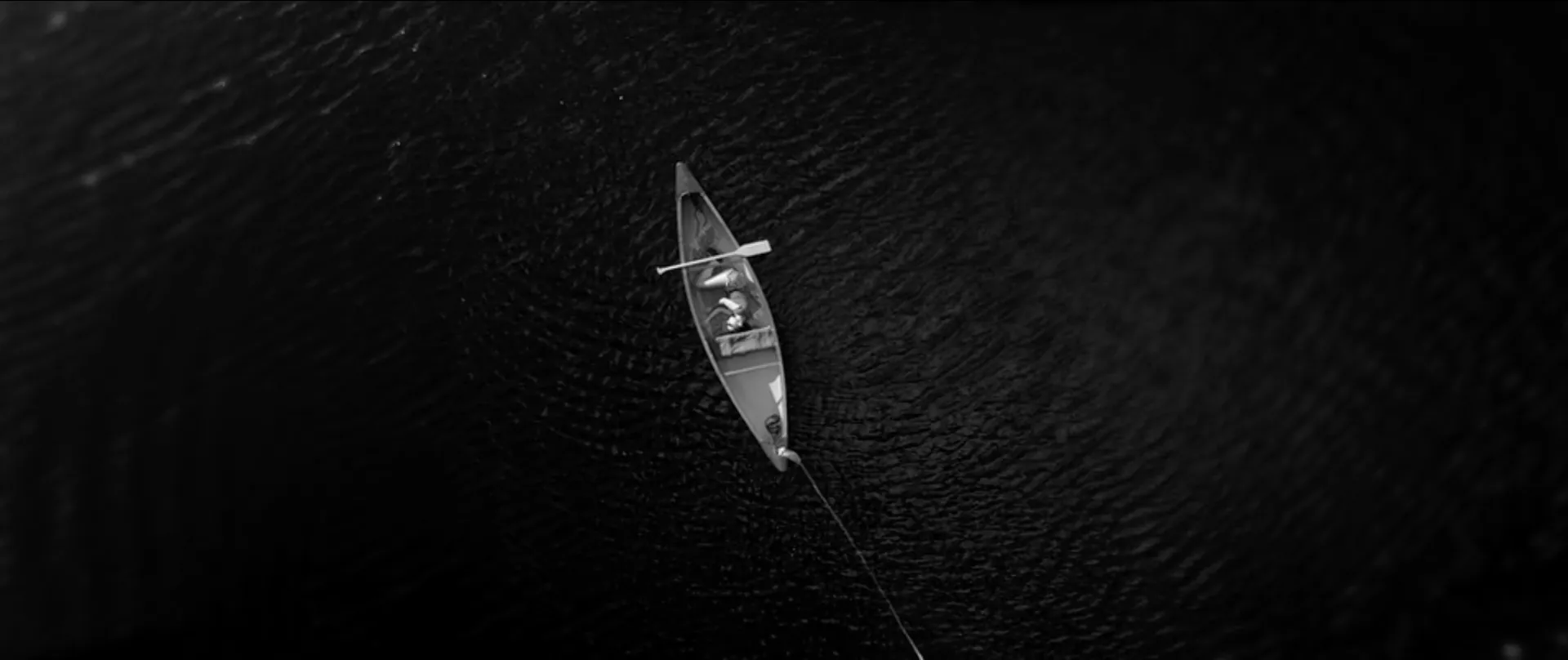 A canoe on dark water, seen from above